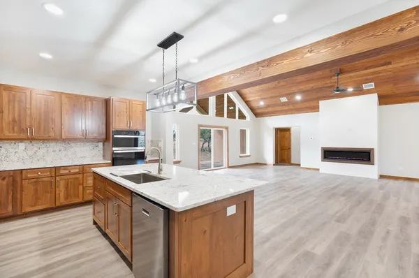 a kitchen with stainless steel appliances granite countertop a sink and dishwasher a stove with wooden floor