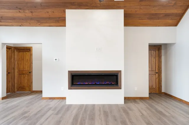 a living room with wooden floor and a fireplace