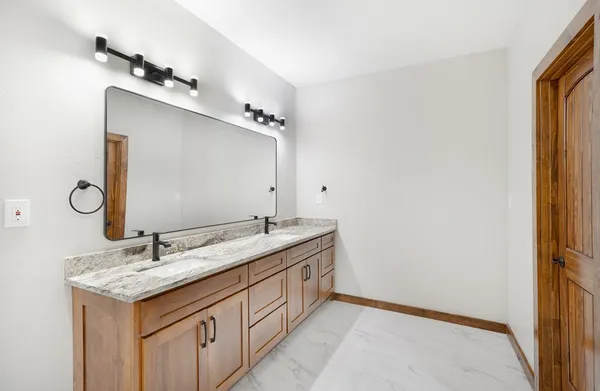a bathroom with a granite countertop sink and a mirror