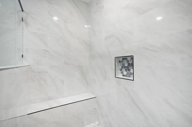 a white toilet sitting next to a white wall