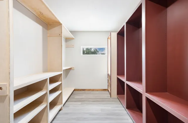a view of walk in closet with wooden floor
