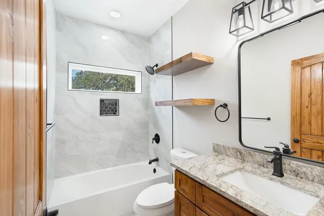 a bathroom with a granite countertop sink toilet and shower