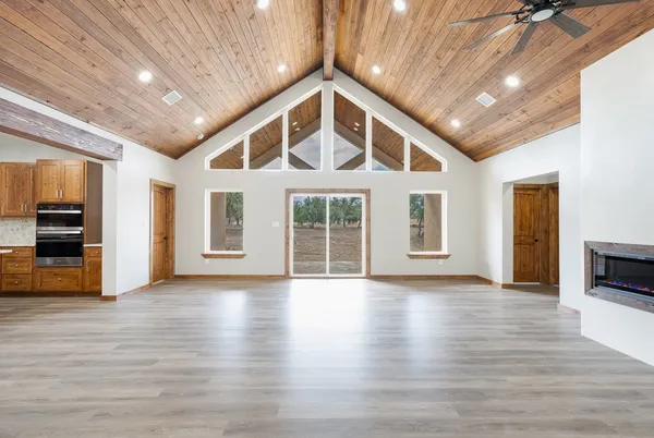 a view of an empty room with wooden floor and a fireplace