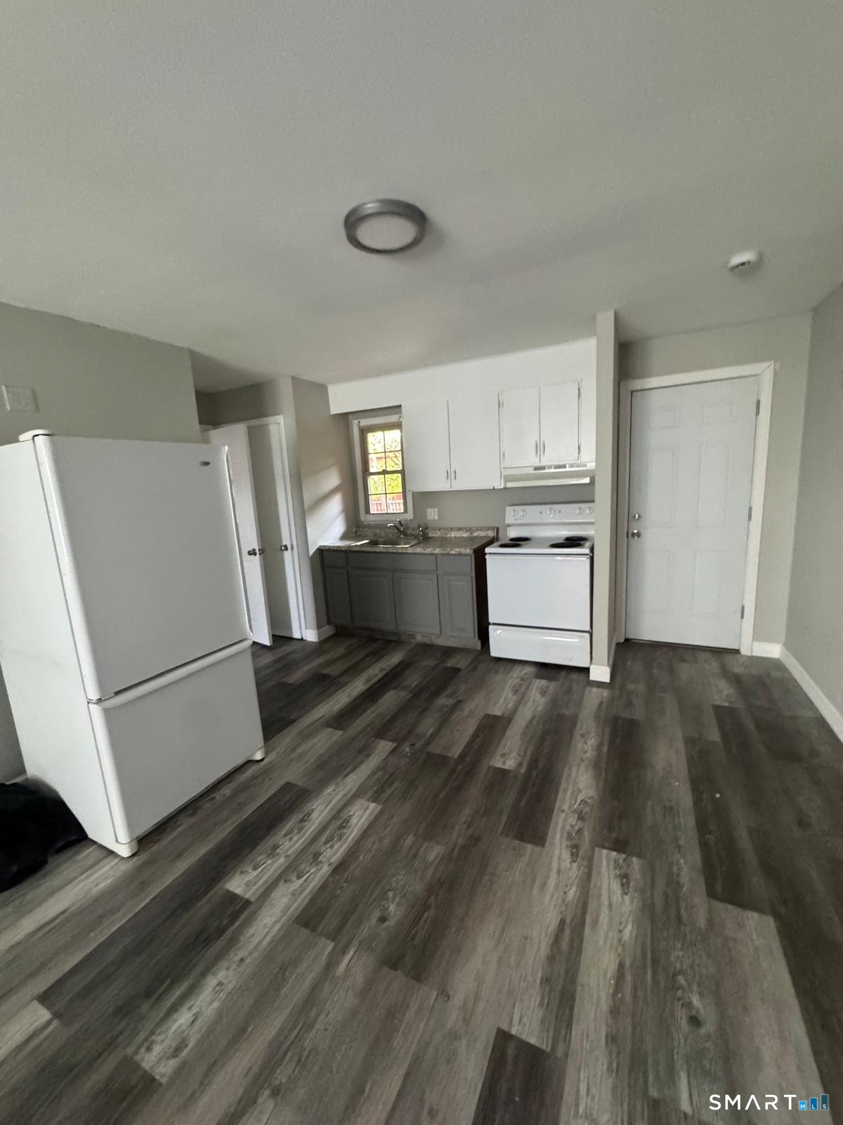 240 Oak Street, Unit 14 Bridgeport, CT 06604 - Photo 1 of 2 a kitchen with a refrigerator and white cabinets