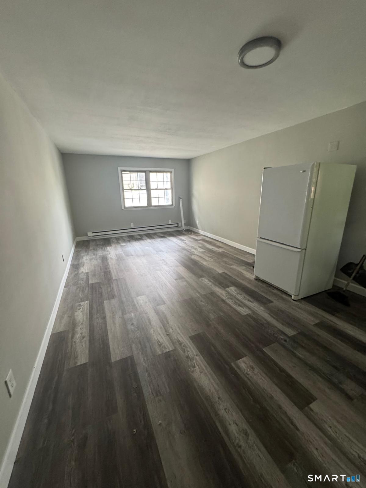 240 Oak Street, Unit 14 Bridgeport, CT 06604 - Photo 2 of 2 a view of a room with wooden floor and a window