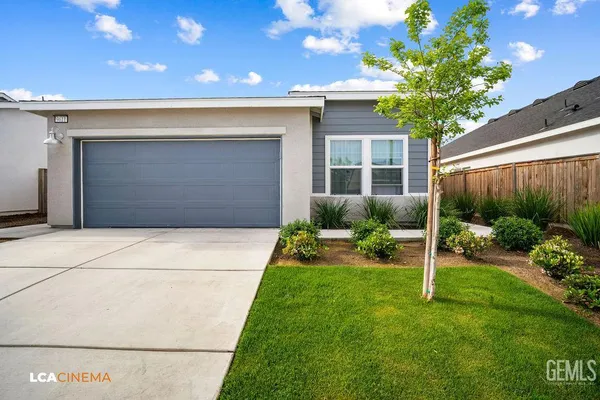 a view of a house with a yard and a garage