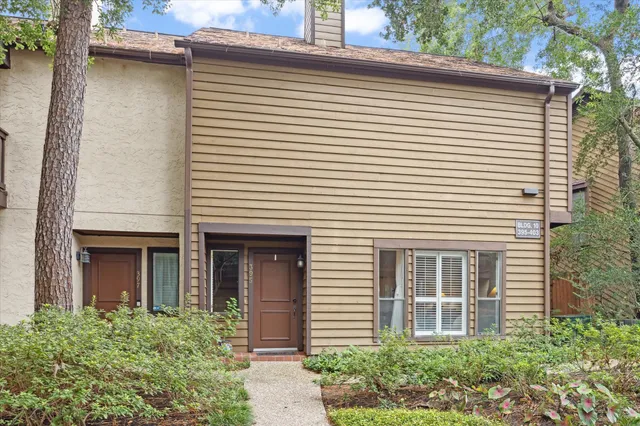 a view of a white house with large windows and a flower plants