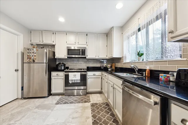 a kitchen with stainless steel appliances a refrigerator sink and microwave