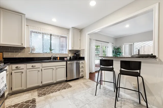 a kitchen with a dining table chairs cabinets and stainless steel appliances