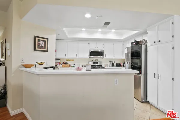 a kitchen with stainless steel appliances a refrigerator sink and cabinets