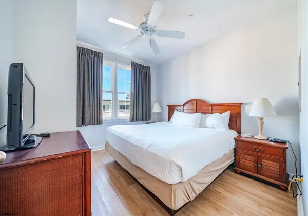 a bedroom with a bed and a flat tv screen on dresser