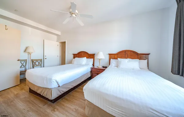 a bedroom with two beds and painting on the wall