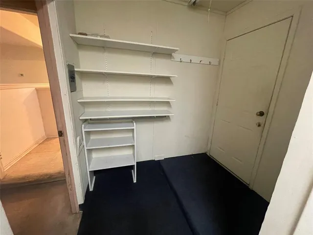 an empty room with a chandelier fan and windows