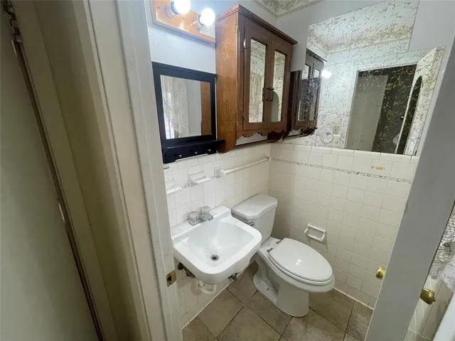 an empty room with chandelier fan and windows