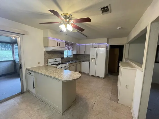 a kitchen with stainless steel appliances granite countertop a sink and a refrigerator