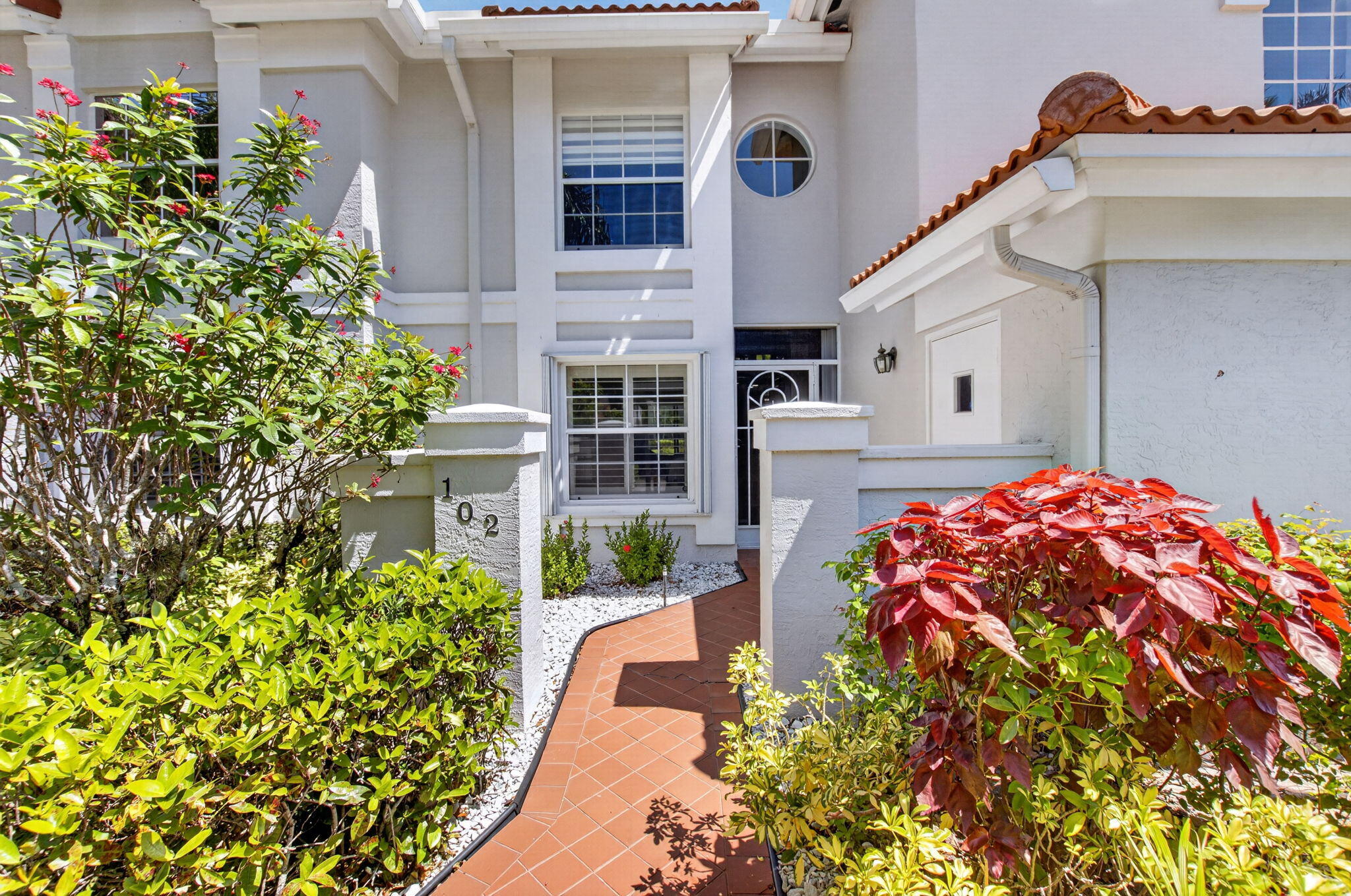 7669 Springwater Place, Unit 102 Boynton Beach, FL 33437 - Photo 1 of 116 a front view of a house with a garden