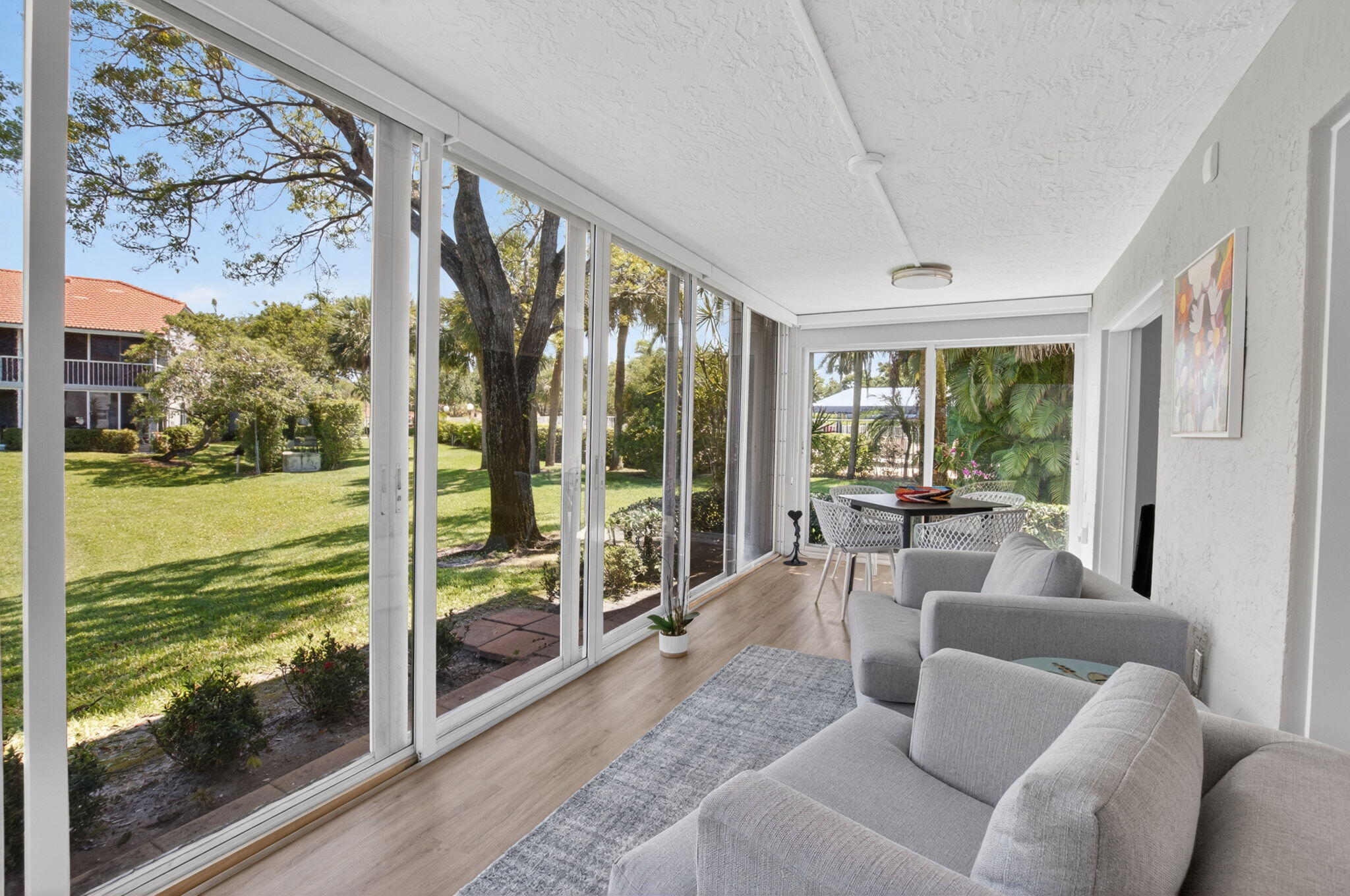 7669 Springwater Place, Unit 102 Boynton Beach, FL 33437 - Photo 37 of 116 a living room with furniture and floor to ceiling windows