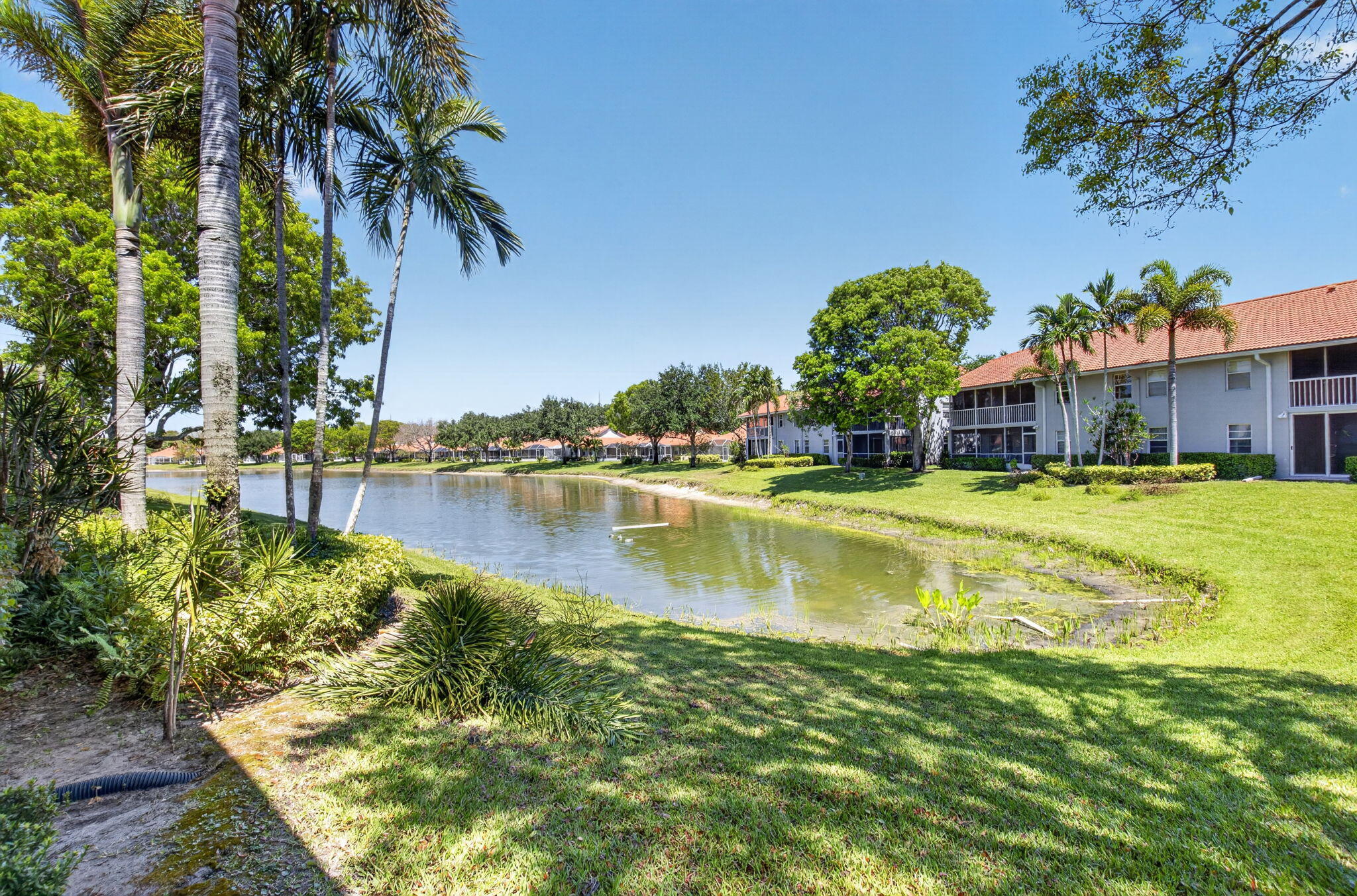 7669 Springwater Place, Unit 102 Boynton Beach, FL 33437 - Photo 41 of 116 a view of a lake with a building in the background