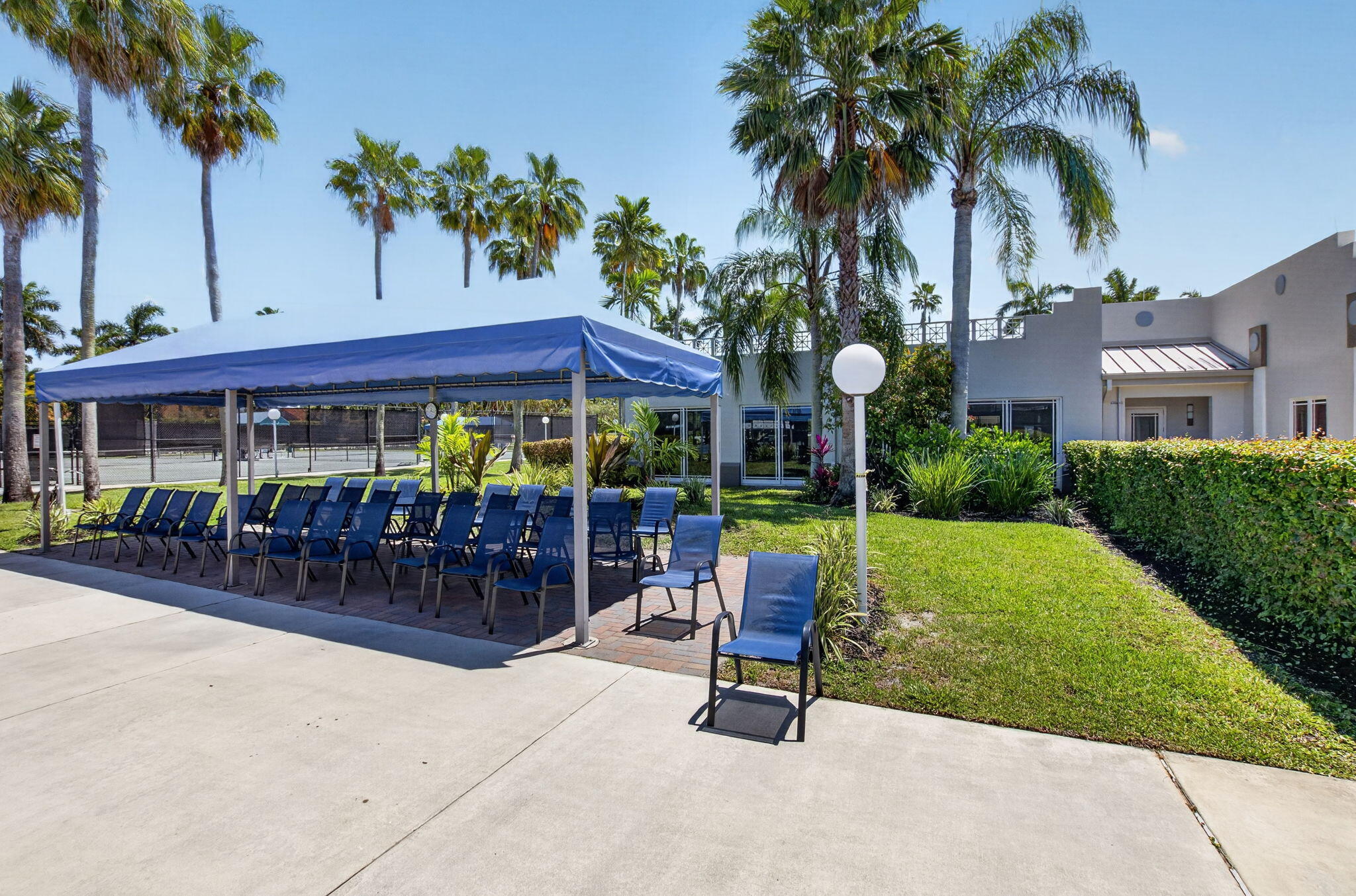 7669 Springwater Place, Unit 102 Boynton Beach, FL 33437 - Photo 83 of 116 a view of a chairs and table in patio and a swimming pool