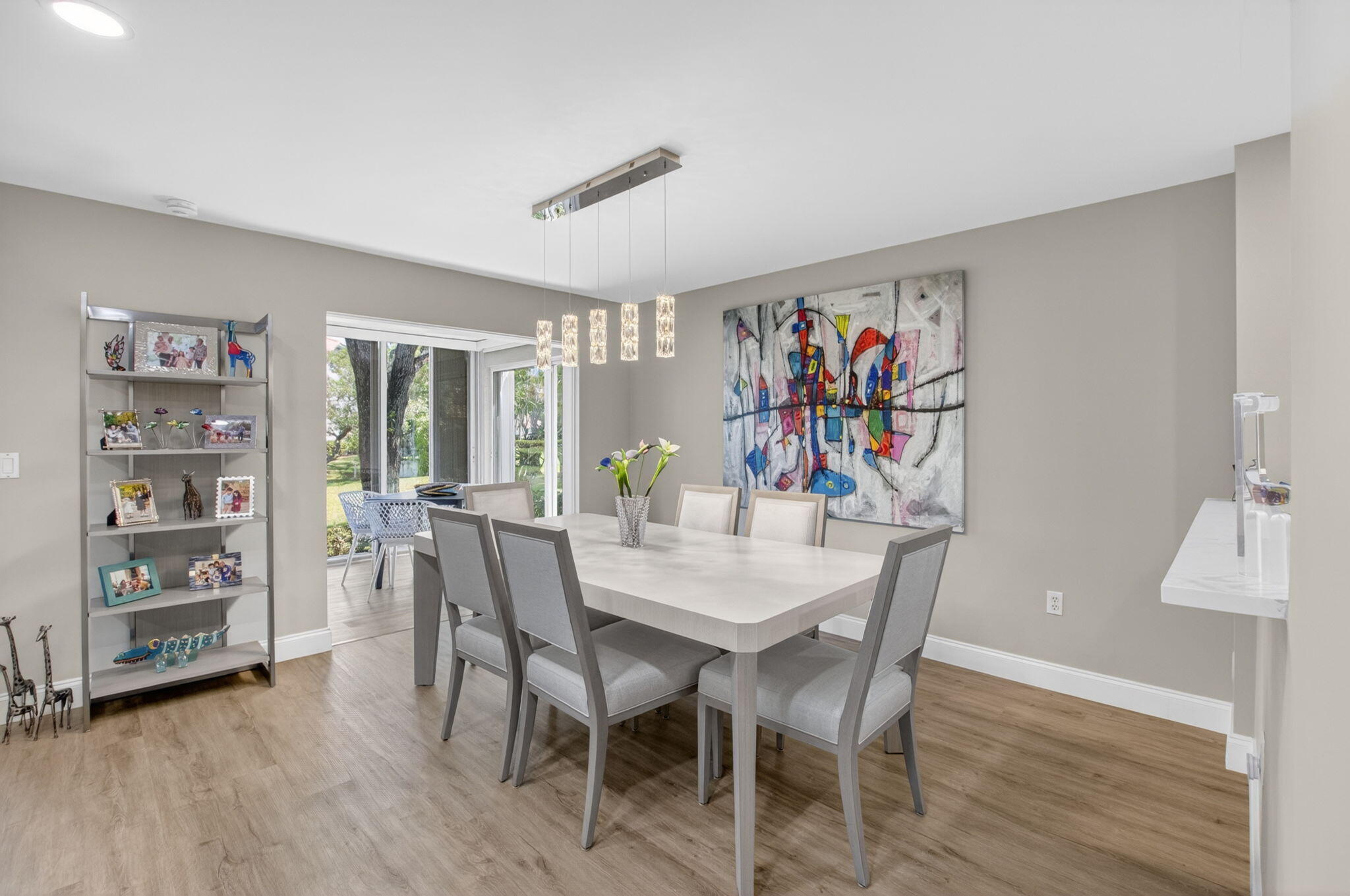 7669 Springwater Place, Unit 102 Boynton Beach, FL 33437 - Photo 9 of 116 a view of a dining room with furniture a chandelier and wooden floor
