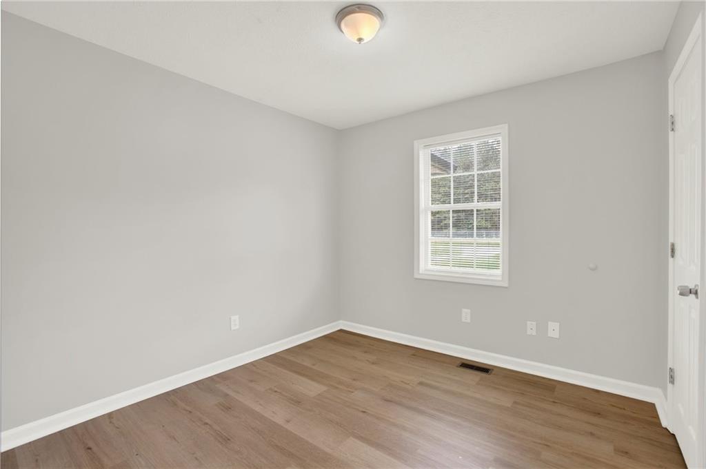 76 Picklesimer Road Southwest Cartersville, GA 30120 - Photo 22 of 43 an empty room with wooden floor and windows
