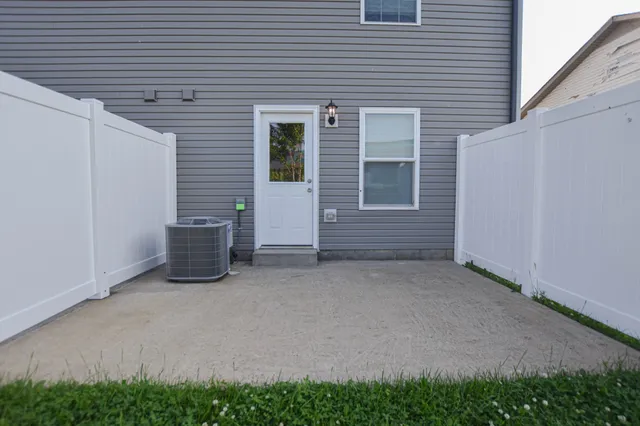 a view of an empty room with a chair and potted plants
