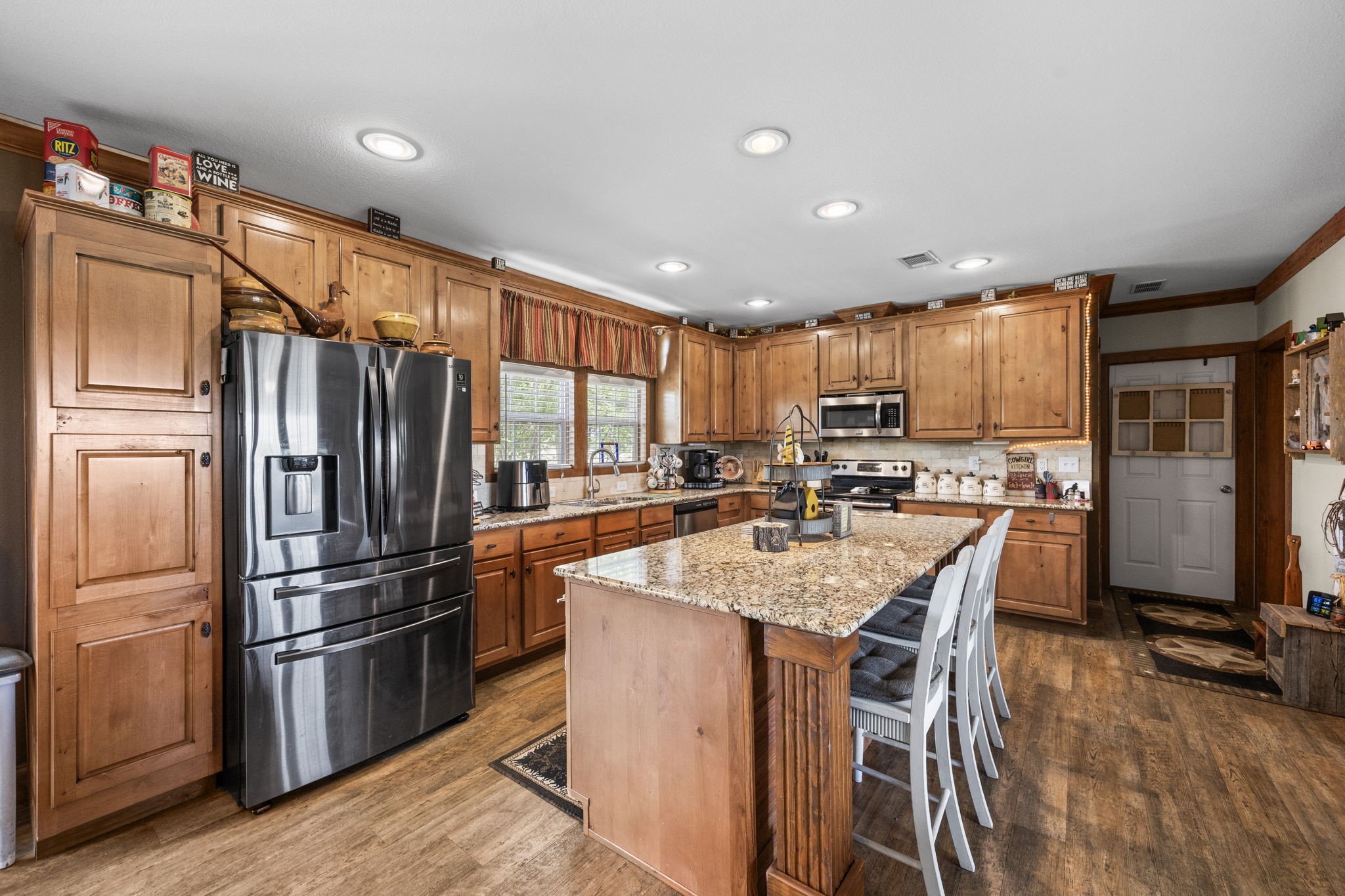 3518 Oil Field Road Bellville, TX 77418 - Photo 12 of 40 a kitchen with stainless steel appliances granite countertop a refrigerator a stove a sink a dining table and chairs