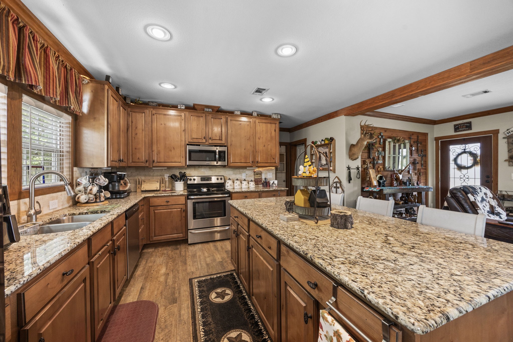 3518 Oil Field Road Bellville, TX 77418 - Photo 13 of 40 a kitchen with granite countertop lots of counter top space a sink appliances and cabinets