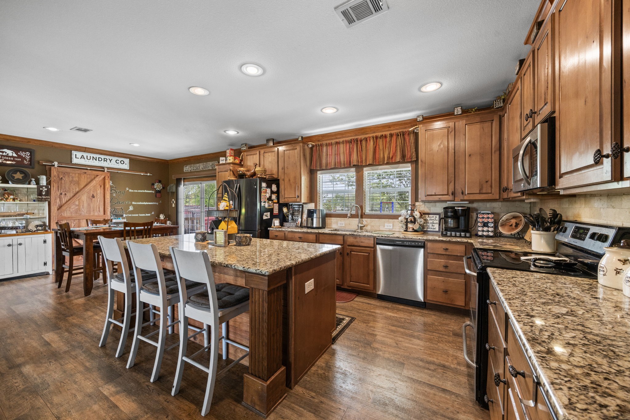 3518 Oil Field Road Bellville, TX 77418 - Photo 14 of 40 a kitchen with stainless steel appliances granite countertop lots of counter top space and wooden floor