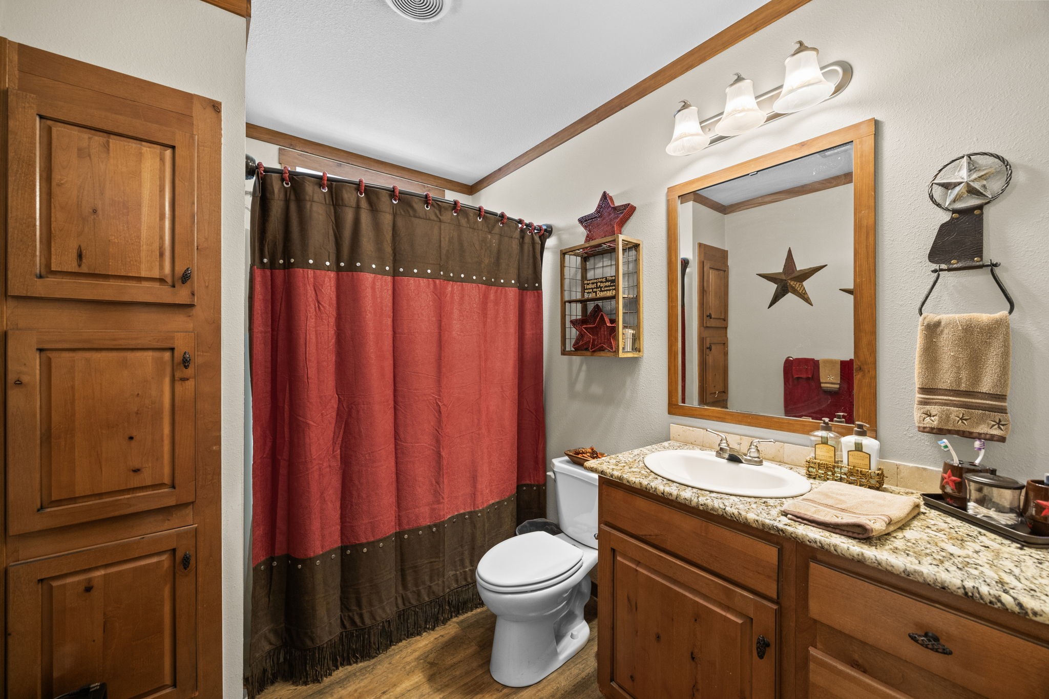 3518 Oil Field Road Bellville, TX 77418 - Photo 22 of 40 a bathroom with a granite countertop toilet sink and mirror