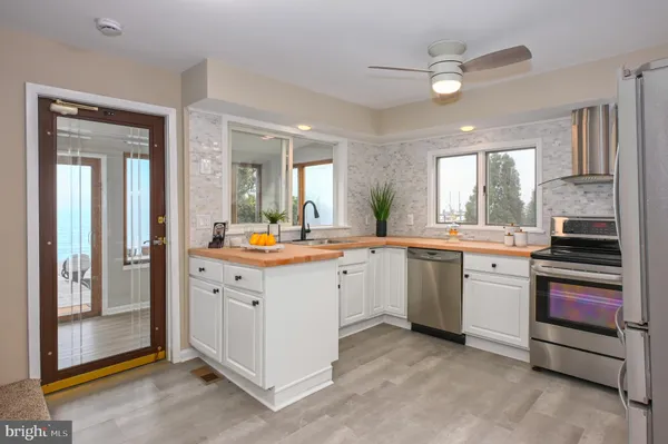 a kitchen with stainless steel appliances granite countertop a stove refrigerator sink and cabinets
