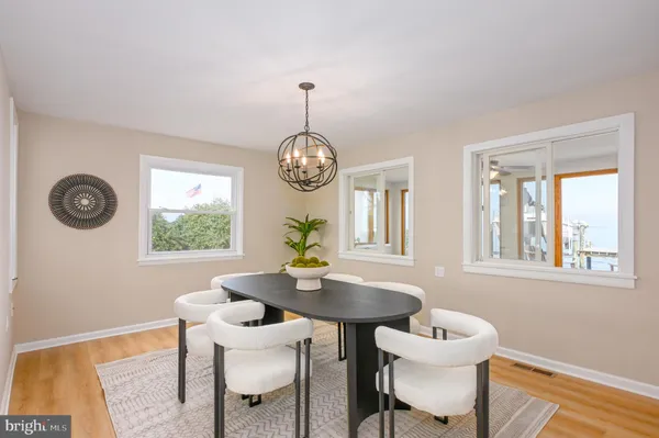 a view of a dining room with furniture a chandelier and wooden floor