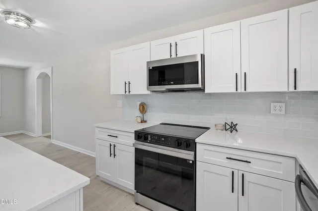 a kitchen with white cabinets stainless steel appliances and sink