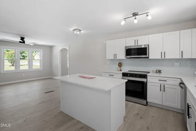 a kitchen with a stove a sink and a microwave