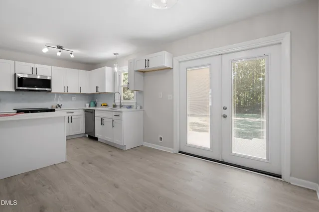 a view of kitchen with stainless steel appliances granite countertop a stove a sink and a refrigerator