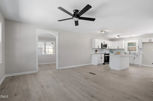 a view of a kitchen with a sink and dishwasher a refrigerator with wooden floor