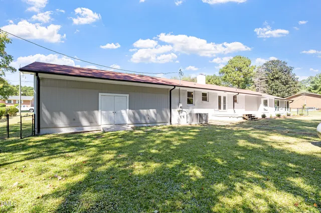 a backyard of a house with table and chairs