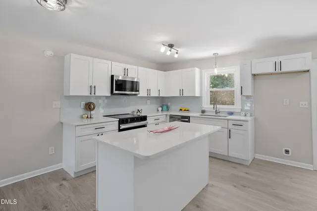 a kitchen with white cabinets and stainless steel appliances