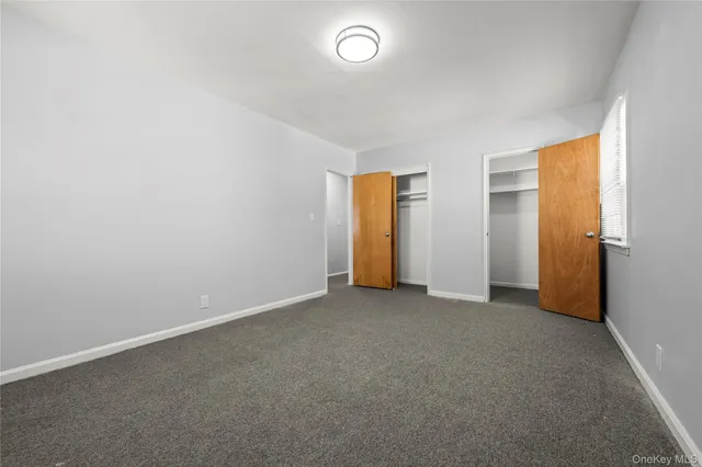 an empty room with closet and a window