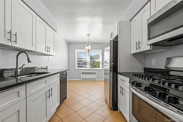 a kitchen with granite countertop a stove sink and cabinets