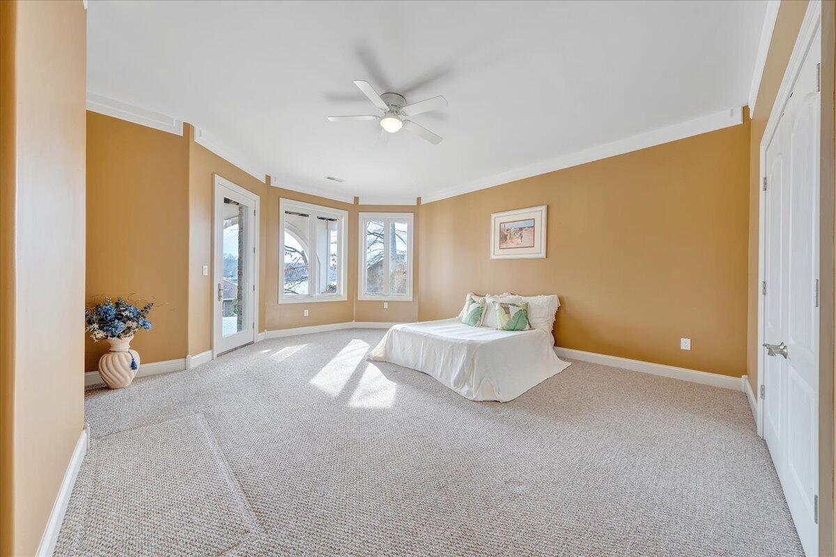 2580 Lakewood Forest Road Moneta, VA 24121 - Photo 76 of 103 a spacious bedroom with a large bed and a chandelier