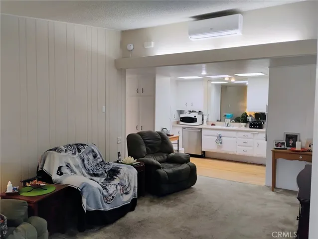 a living room with furniture and view of kitchen