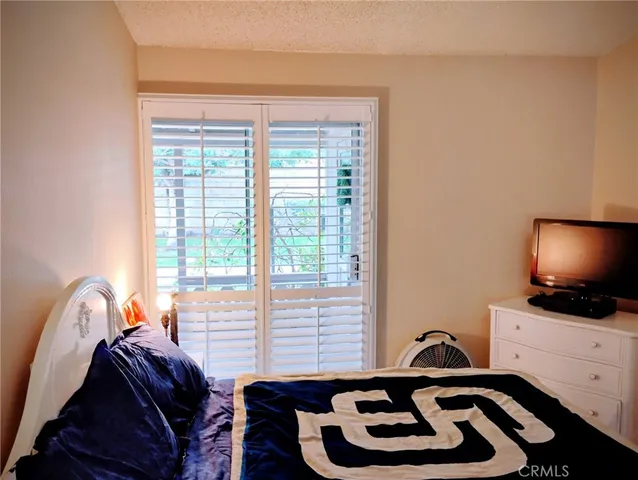 a bedroom with a bed and a flat tv screen