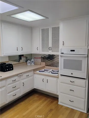 a kitchen with granite countertop white cabinets and white appliances