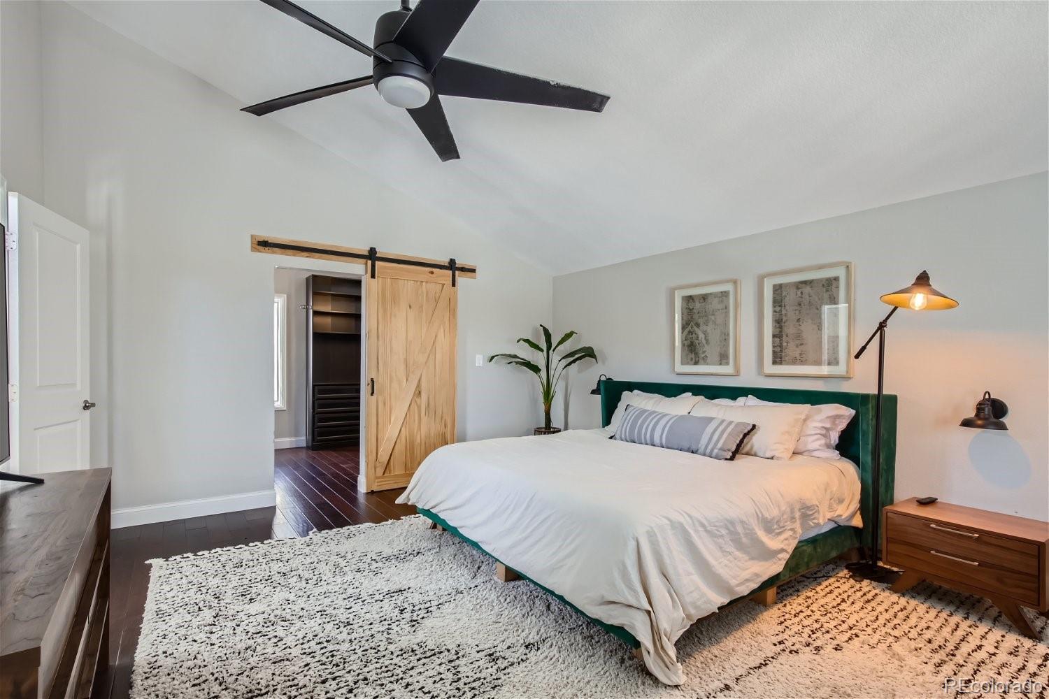 27732 Squaw Pass Road Evergreen, CO 80439 - Photo 14 of 33 a bedroom with a large bed and a chandelier