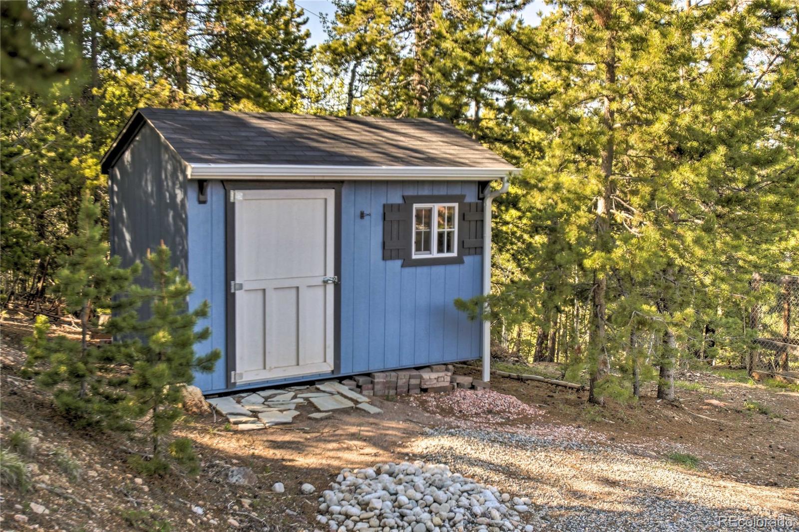 27732 Squaw Pass Road Evergreen, CO 80439 - Photo 26 of 33 a house with trees in front of it