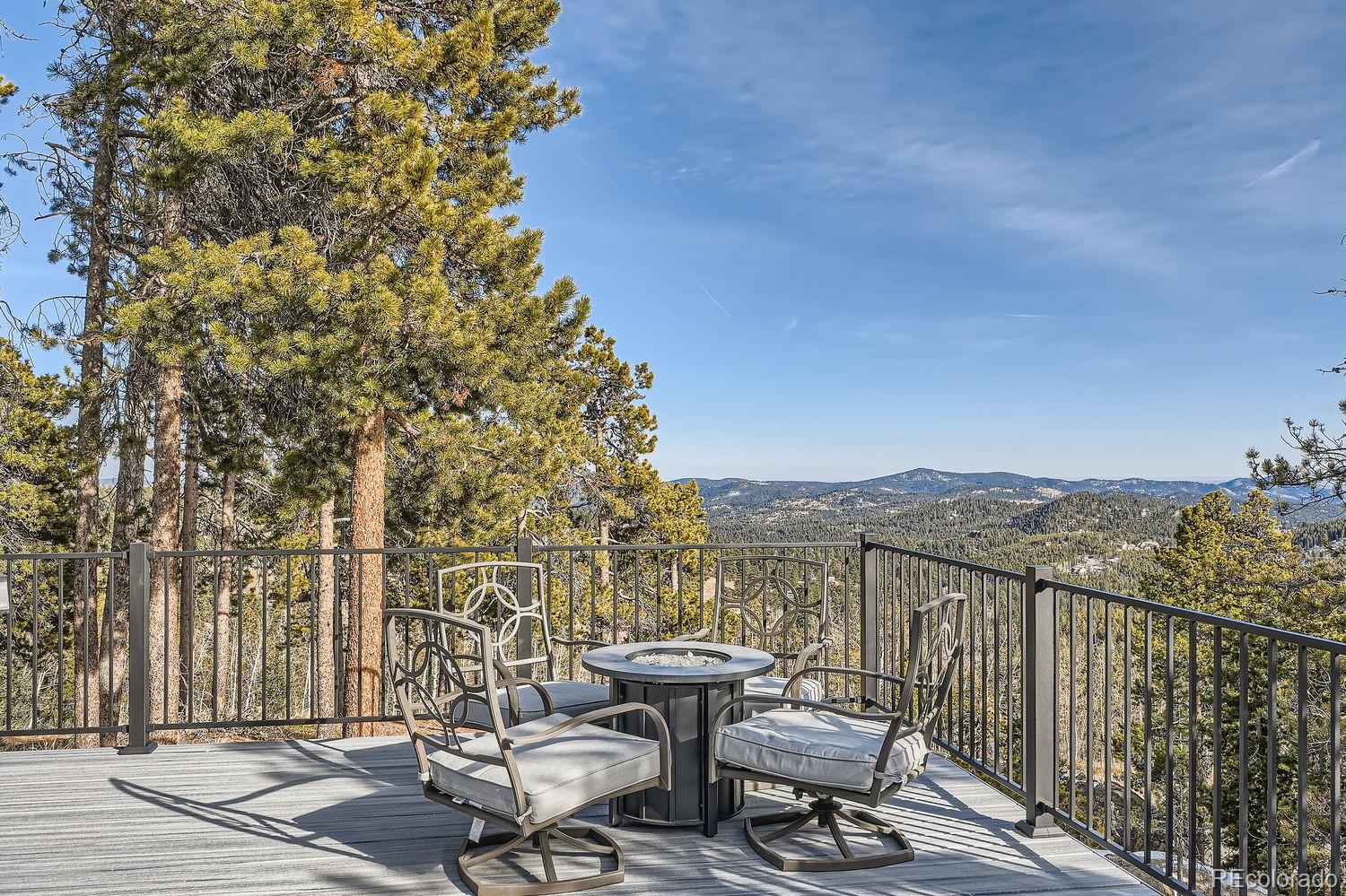 27732 Squaw Pass Road Evergreen, CO 80439 - Photo 27 of 33 a view of a balcony with table and chairs and wooden fence