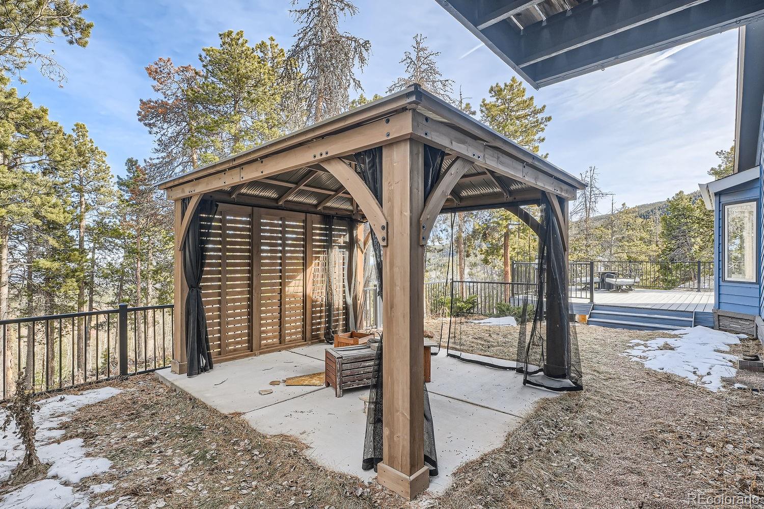 27732 Squaw Pass Road Evergreen, CO 80439 - Photo 30 of 33 a view of backyard with large trees and wooden fence