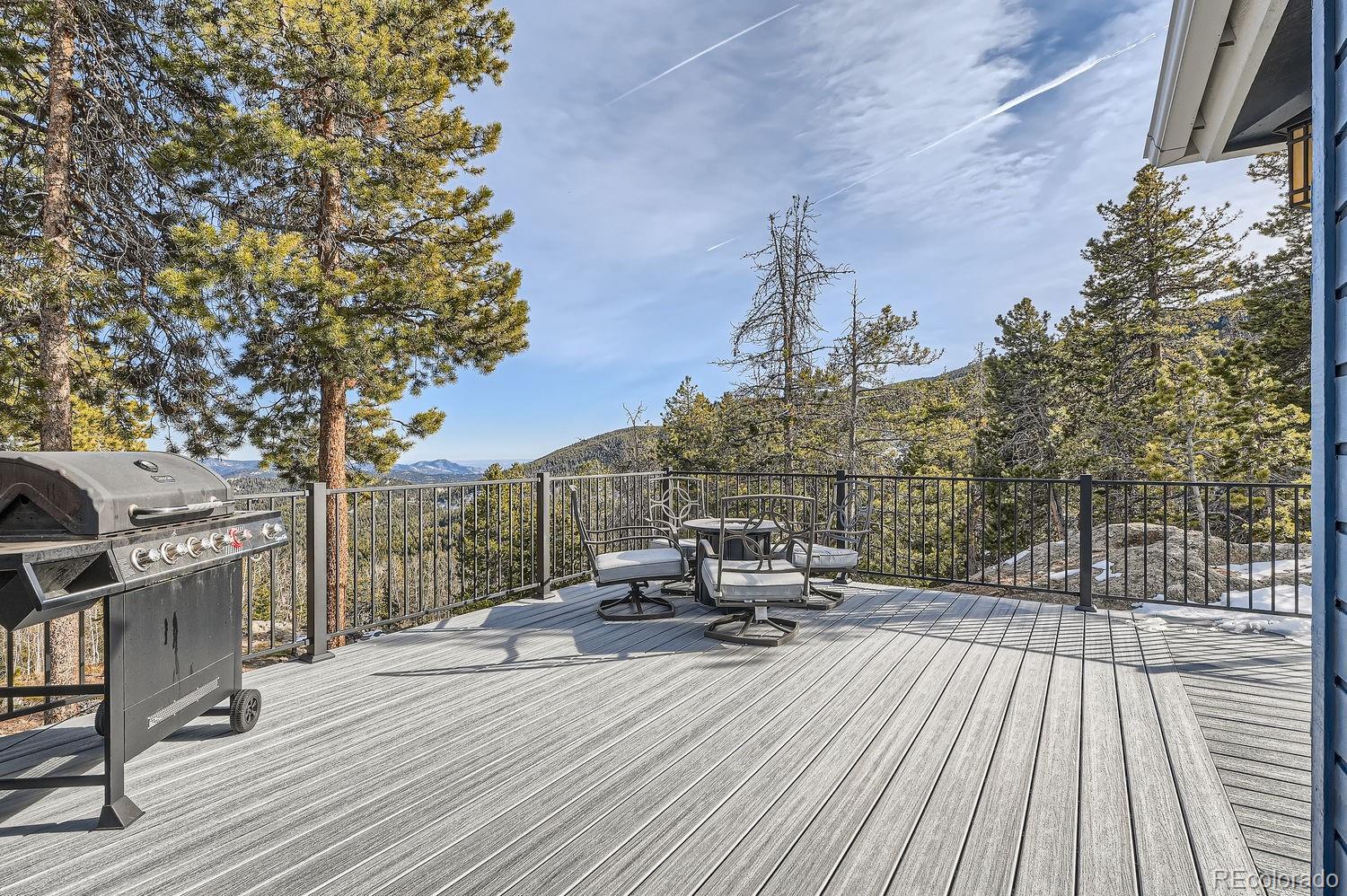 27732 Squaw Pass Road Evergreen, CO 80439 - Photo 32 of 33 a view of a roof deck with table and chairs a barbeque with wooden floor and fence