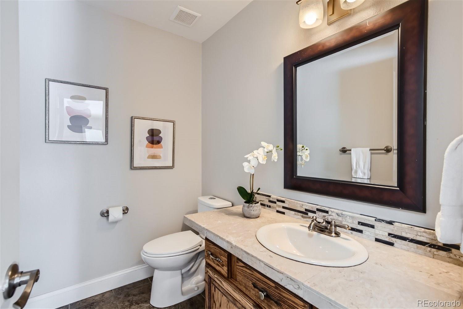 27732 Squaw Pass Road Evergreen, CO 80439 - Photo 8 of 33 a bathroom with a granite countertop toilet sink and mirror